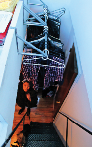 Nicole Chu, 20, hangs her wardrobe over her loft staircase. Her 200 square foot West Village micro-apartment requires her to walk through her makeshift closet in order to use the bathroom. (Henry Miller)