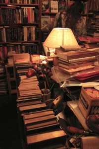 Throughout Brazenhead, piles of books are scattered on tabletops amongst misplaced pipes and yellowing photographs. Photo by Ivy Meissner