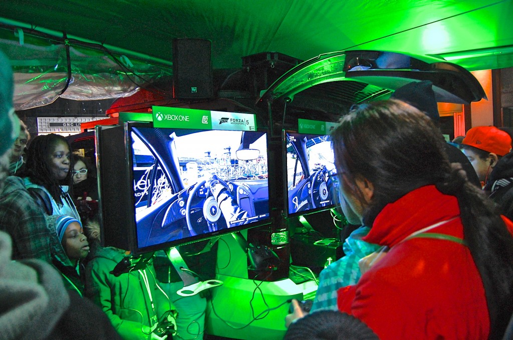 Gamers huddled around screens and watched others play the new racing game, Forza Motorsport 5.