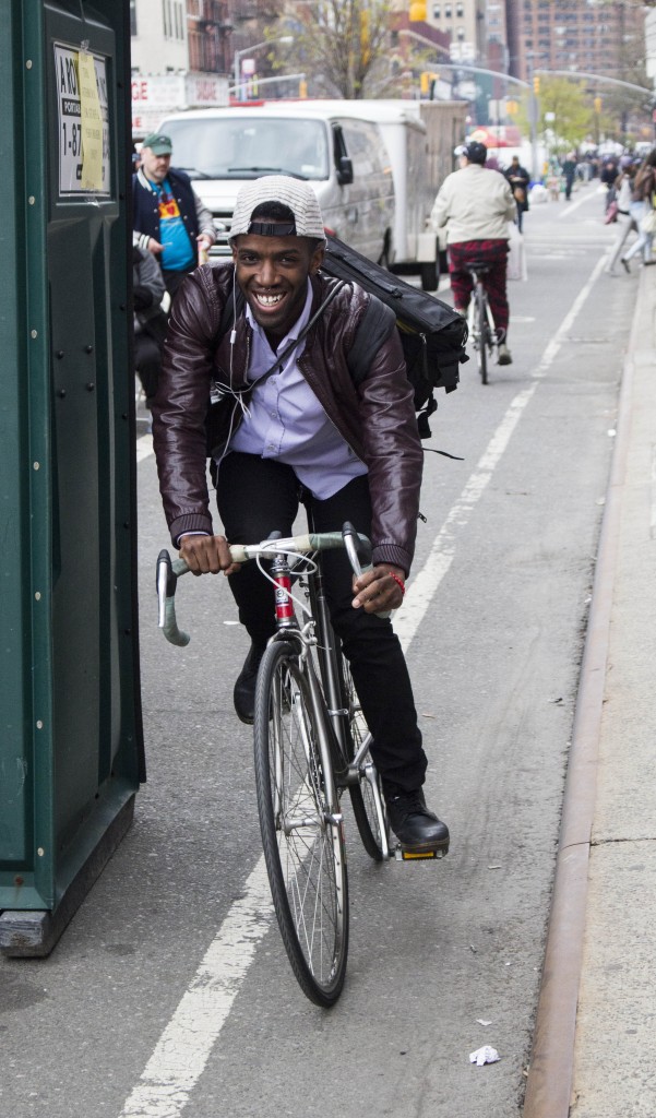 A cute guy having a good day riding his bike through Chelsea. 
