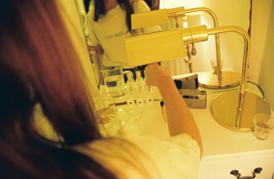 Several bottles of Jo Malone perfume, a mirror found on the street and a gifted, vintage lamp adorn Hazel's hand painted dresser. 