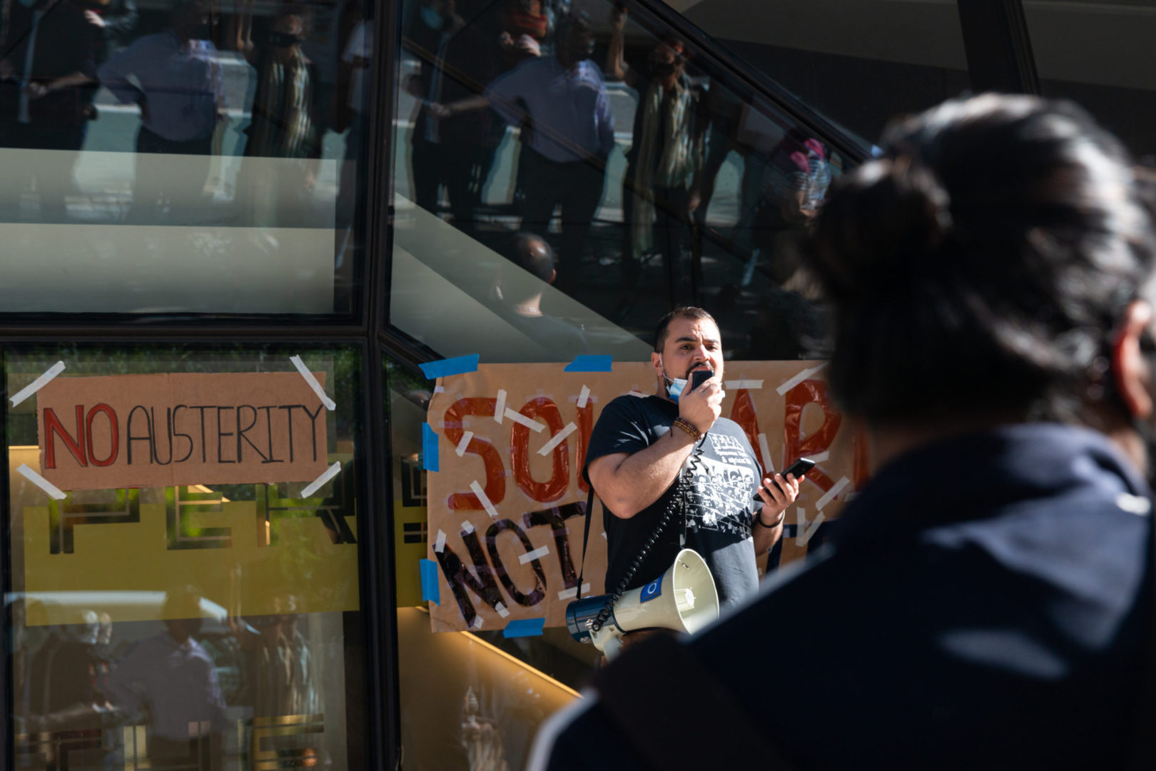 Daniel Younessi addresses the crowd at a rally against 122 layoffs. Photo by Quinn Kowitt