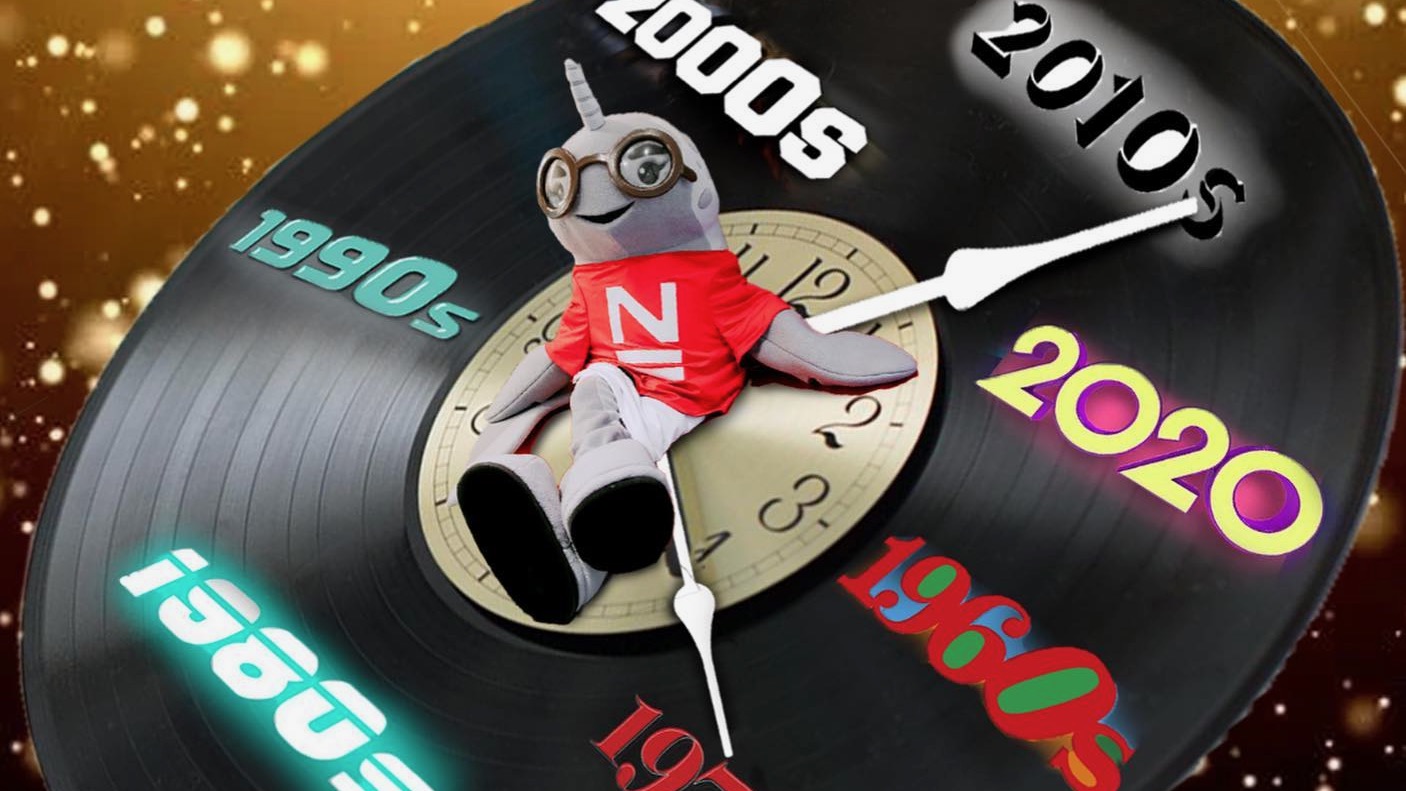 A photoshopped image of a person wearing the new school mascot narwhal costume on a large vintage record turned into a clock, with the minutes replaced as decades from the 1960s to the 2010s, each in a font reminiscent of the decade