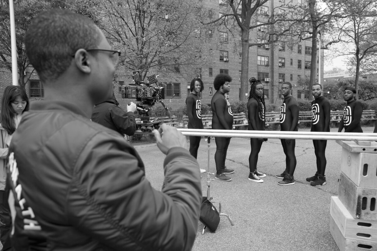 Director filming a scene of Black men wearing human target bodysuits.