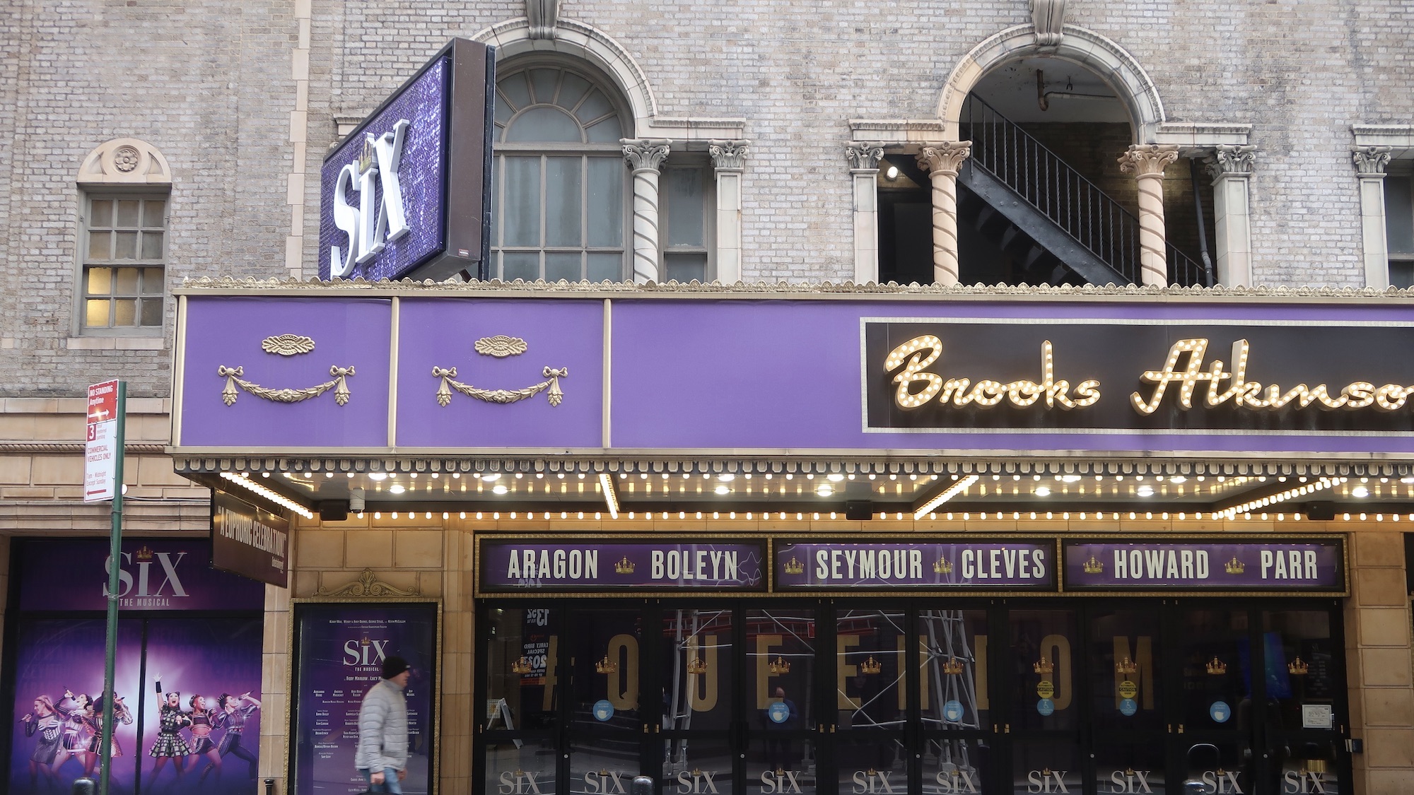 The exterior of the Brooks Atkinson theater featuring purple and gold posters advertising the musical.