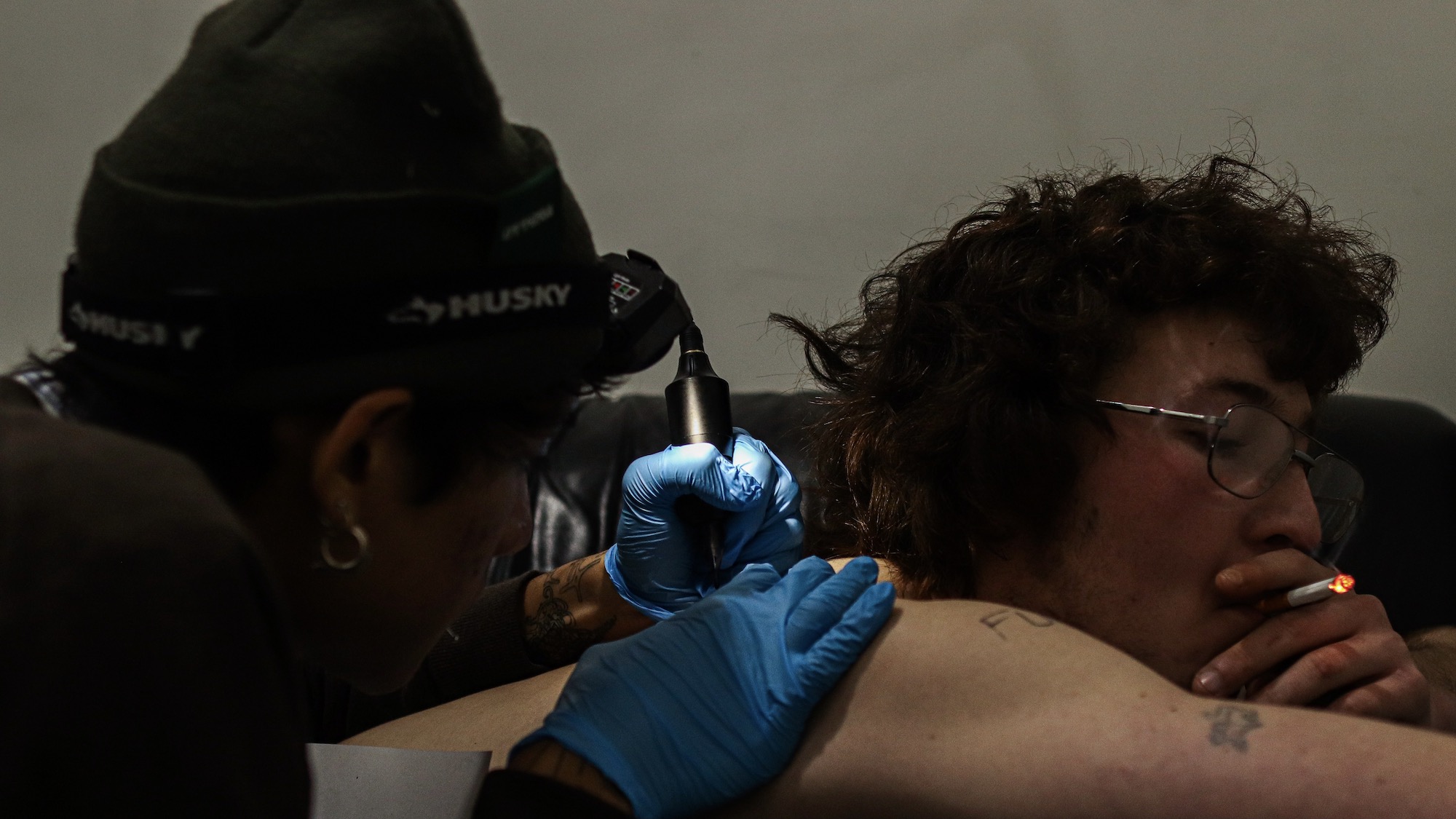A man tattooing another man