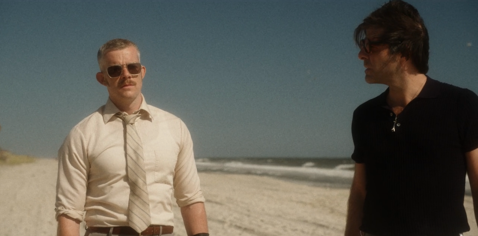Two white men on the beach during the daytime.