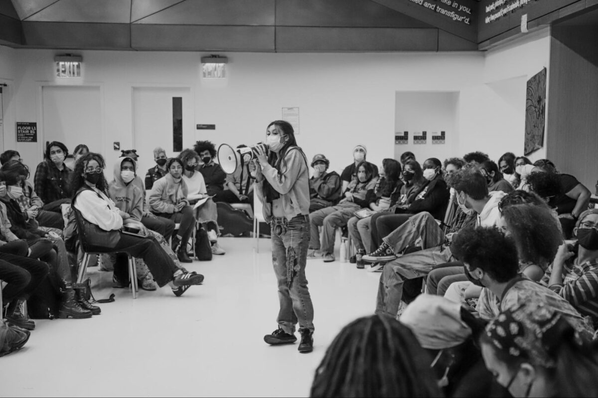 Students listen to a speaker with a bullhorn during a sit-in for the occupation at The University Center event cafe.