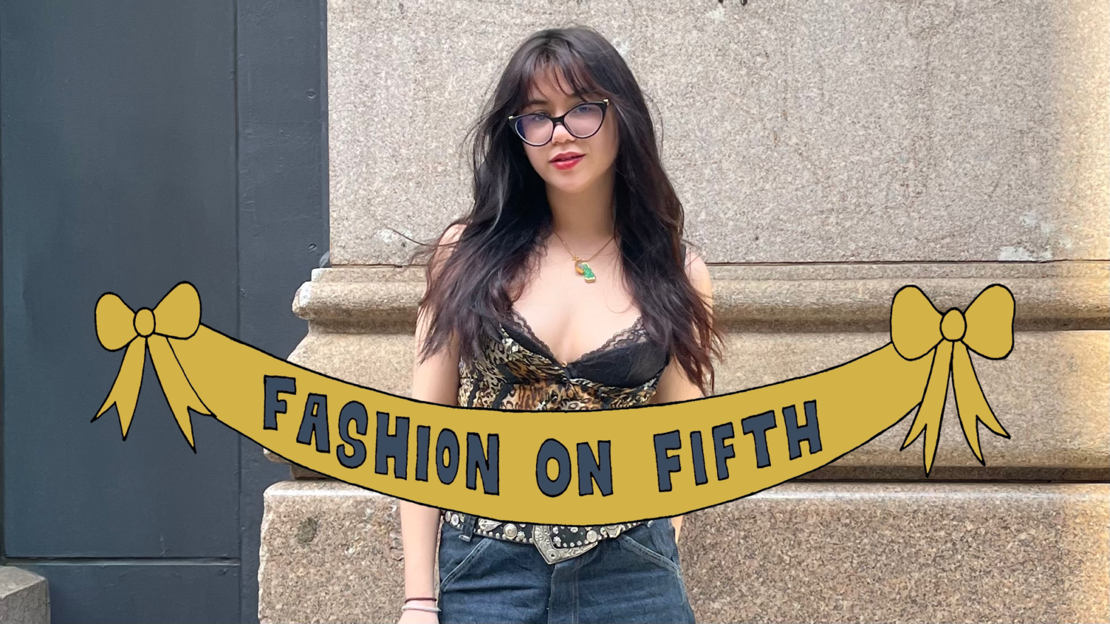 A young female student with glasses and long brown hair wears a leopard print tank top, a bedazzled belt, and jean shorts behind a yellow banner that says “Fashion on Fifth” in bold blue letters.