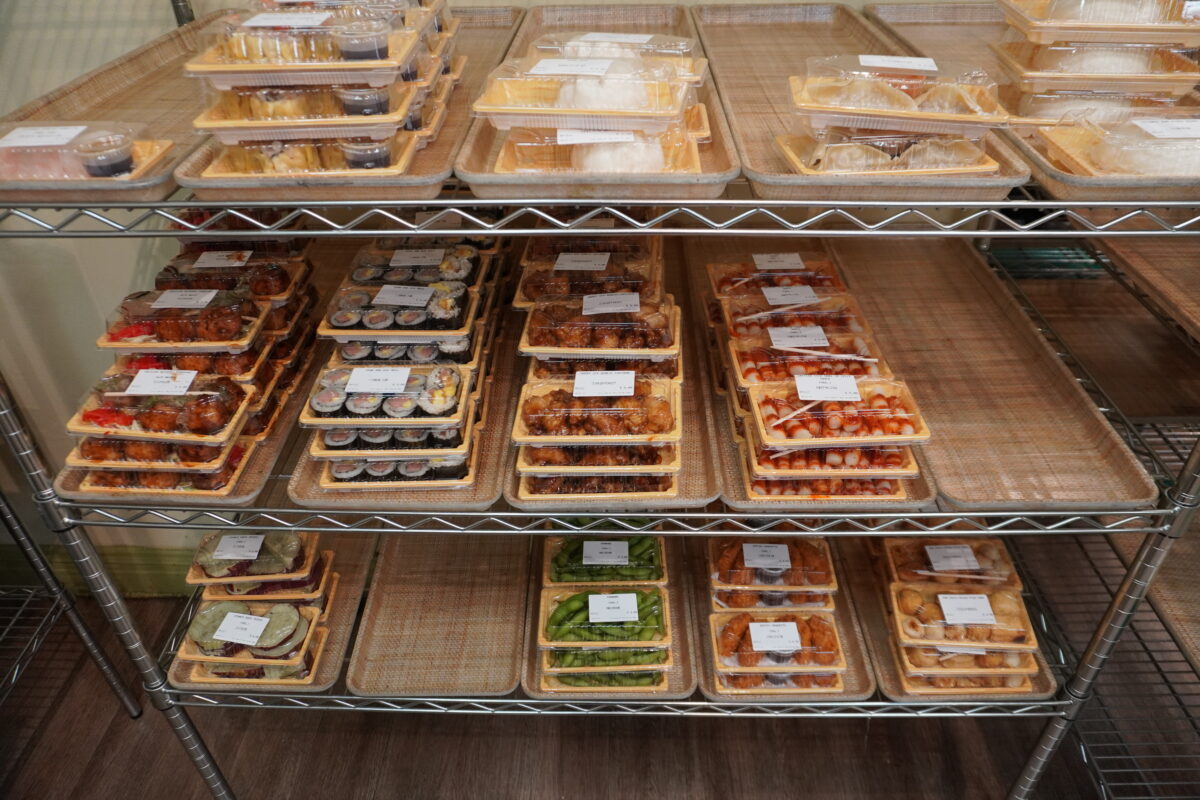 A shelf with boxes of prepared food.