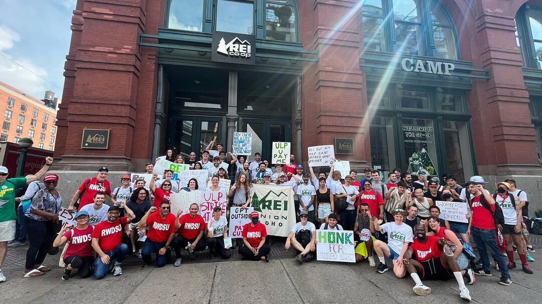 The union outside the REI Soho location wearing red union shirts and holding signs after their most recent strike.