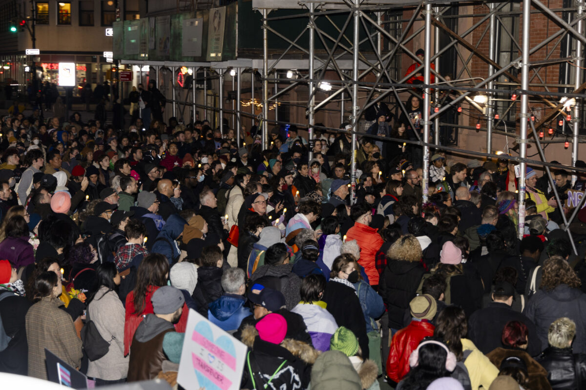 Image of a birds eye view of a large crowd gathered in front of stonewall Inn. The crowd faces one direction as they listen to speeches