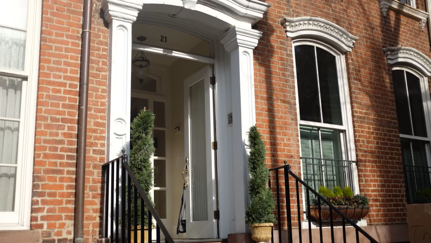 Image of the President's townhouse. It is a brownstone building with white trimming around windows and door.