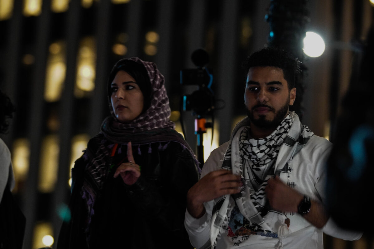 Leaders of WOL Palestine stand on a platform overlooking the crowd 