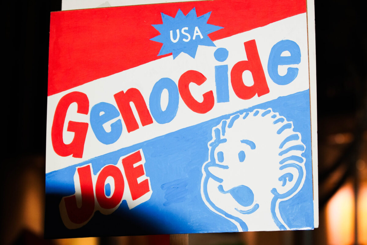 Red, white, and blue sign reads “USA Genocide Joe”