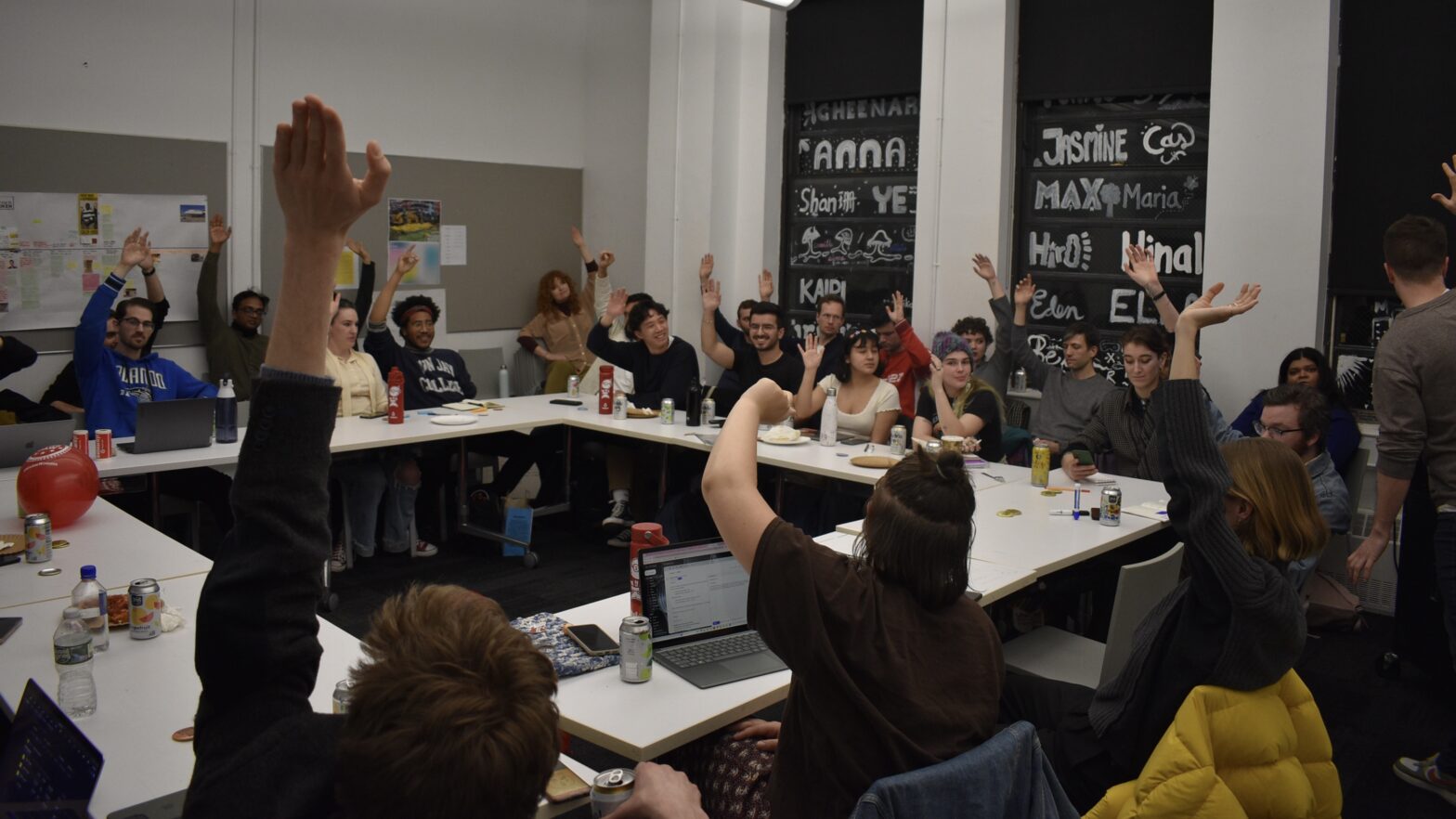 SENS members raise hands while seated at tables to vote in favor of a March 6 strike deadline.