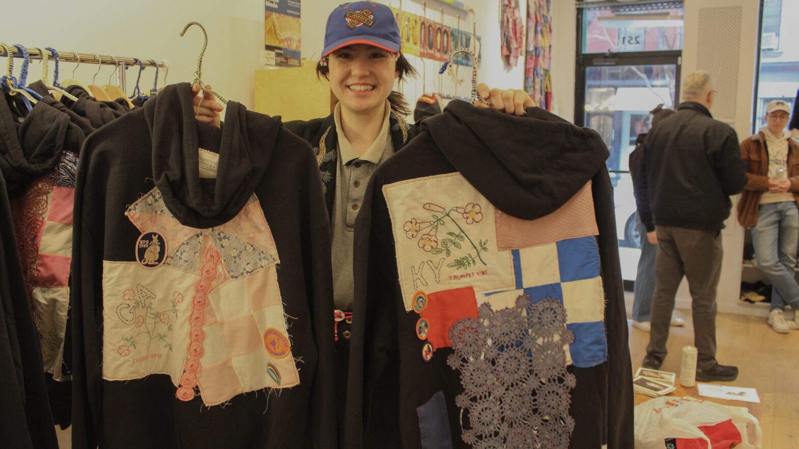 Isabella Li Kostrzewa holding two patchwork Isaboko sweatshirts