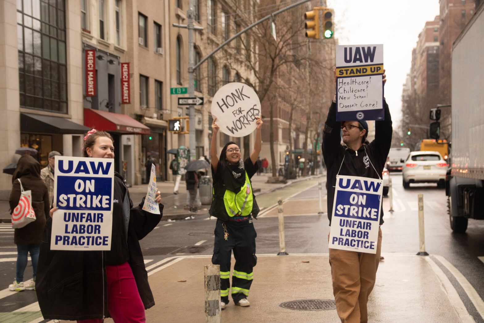 TNS YDSA member holds "Honk for workers sign" up