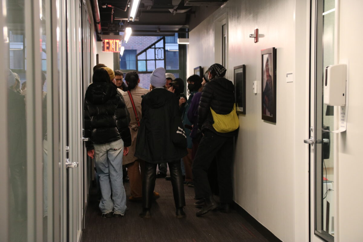 A group of protesters gathered at the end of a hallway.