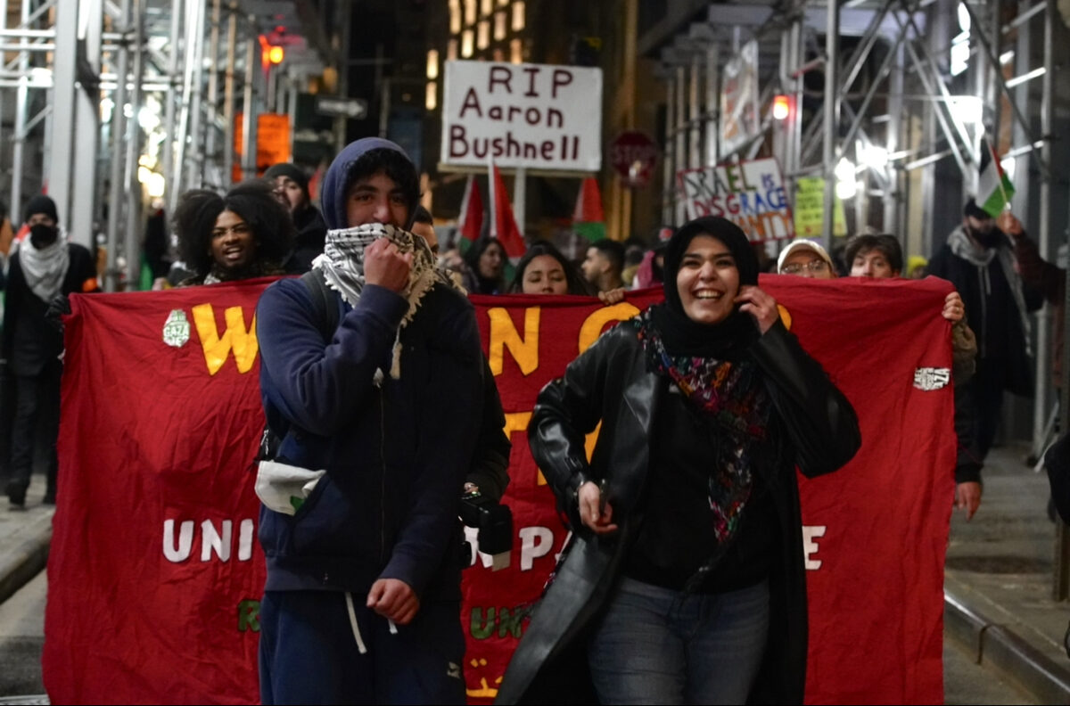 Two protesters laugh and exchange jokes as they lead the crowd.