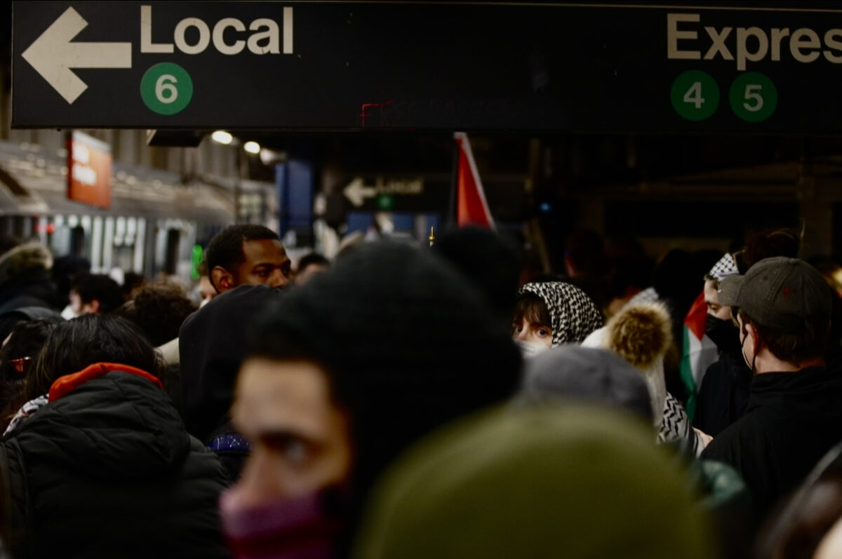 crowds of people stand around the subway platform with signs pointing towards "Local" and "Express"
