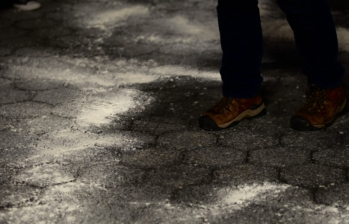 Brown hiking shoes walk on a flour covered ground 