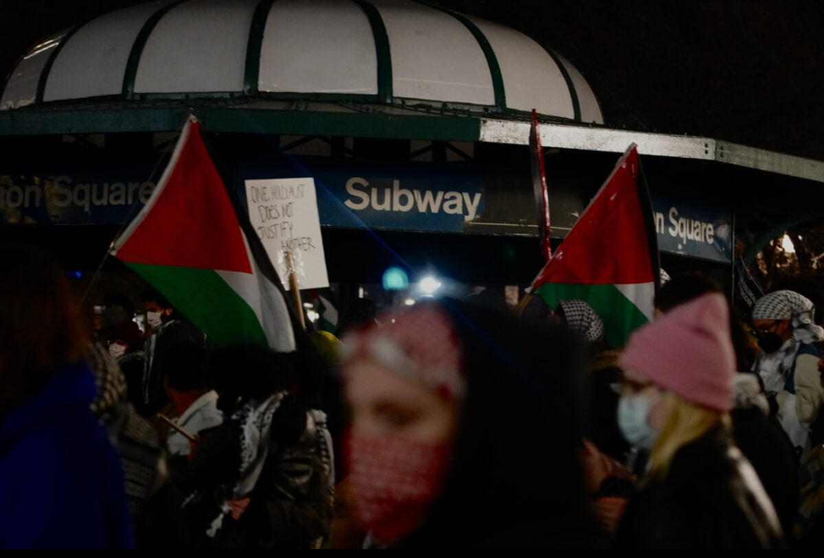 crowd of people with flags in front of union square subway station 