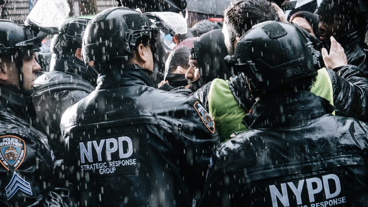 NYPD detaining someone in the pouring rain