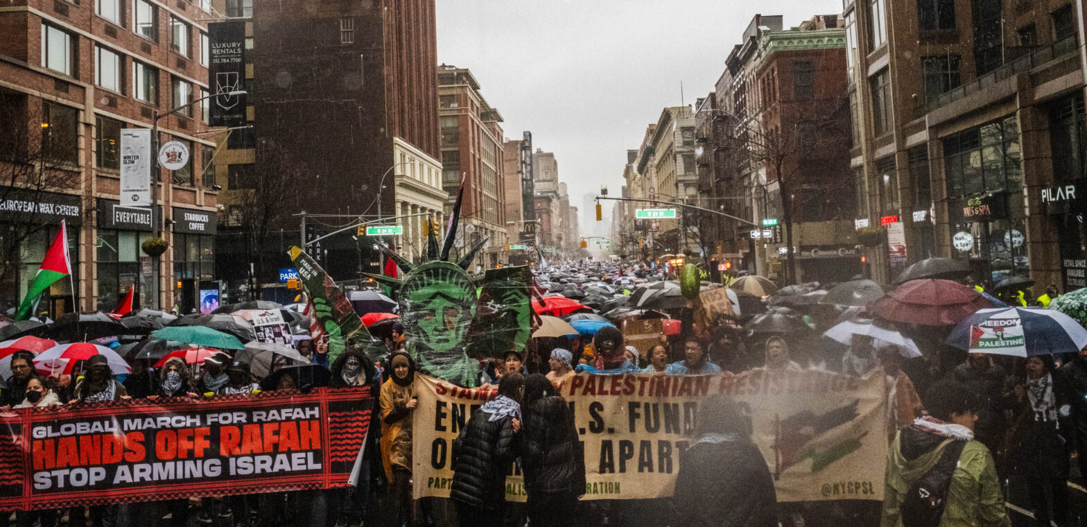 Protesters marching down the street holding colorful signs