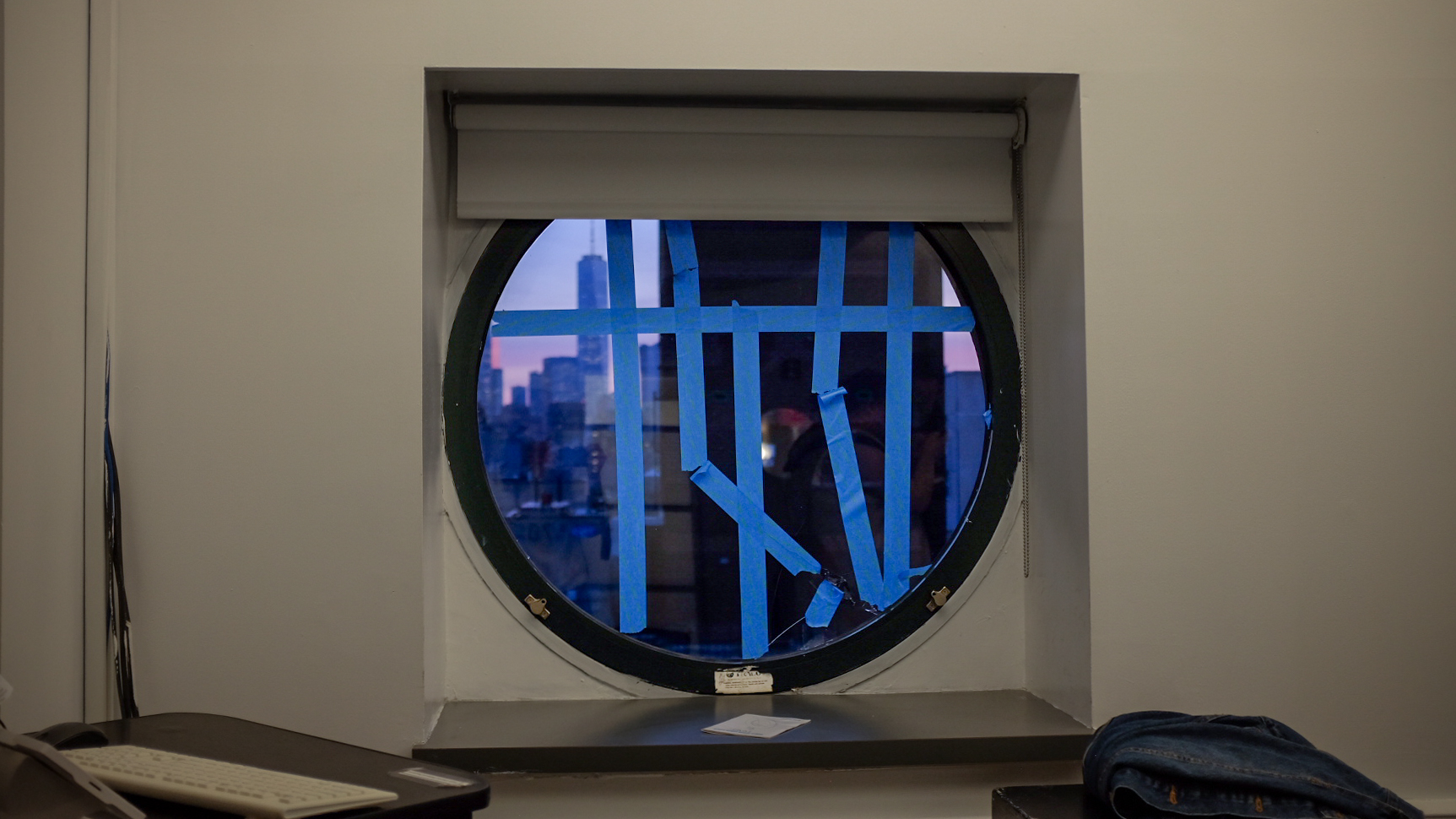 Image of a circular window with tape covering cracks.