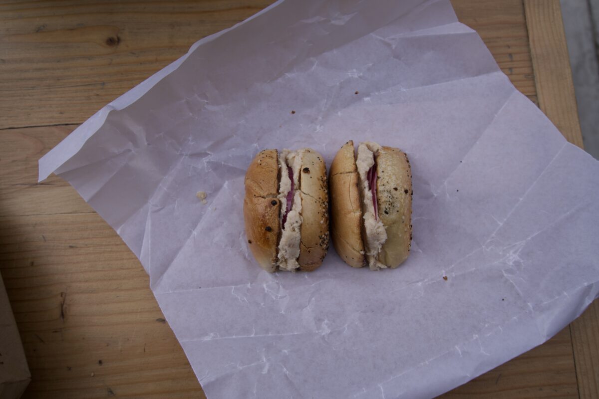 n unwrapped everything bagel with whitefish salad and onions.