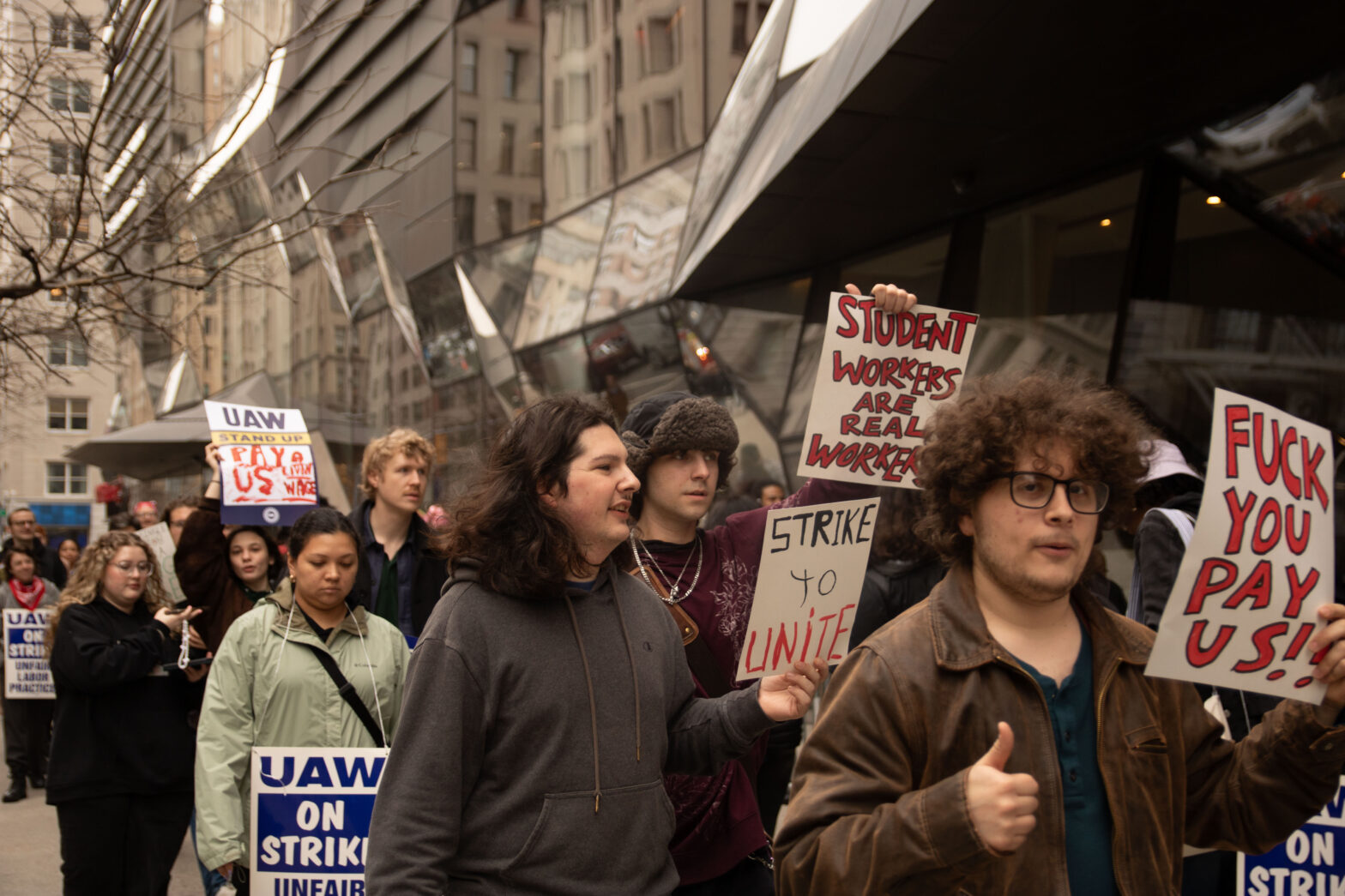 Students and faculty holding up signs at the picket line outside the University Center.