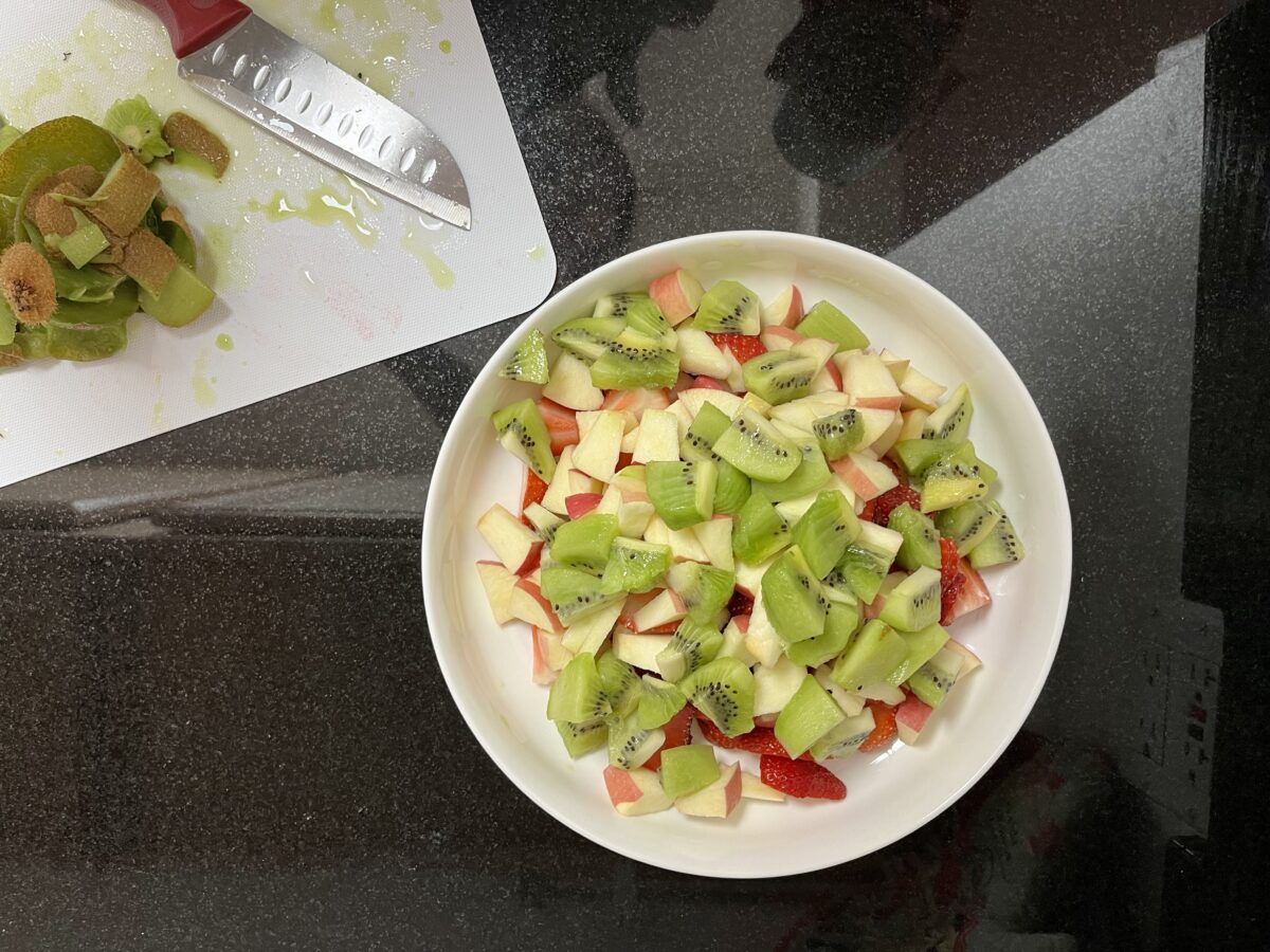 Fruit salad with slices of apple, kiwi, and strawberries
