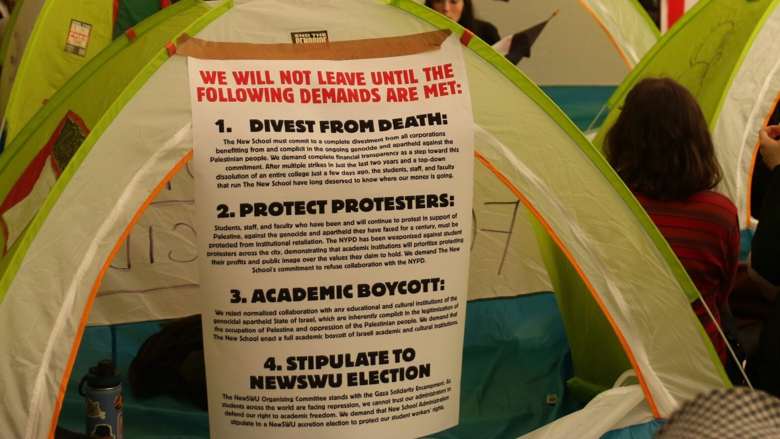 sign taped onto a blue and green tent