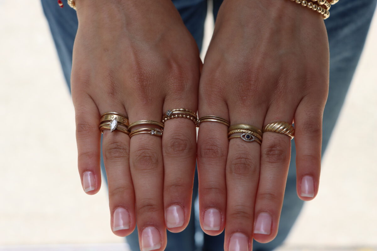Close-up of students' hands and the gold rings on her fingers.
