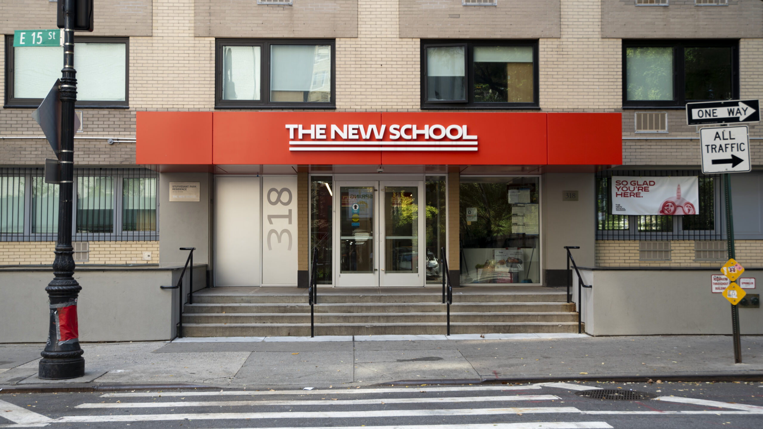 Entrance to a building with a red sign that says “The New School”.