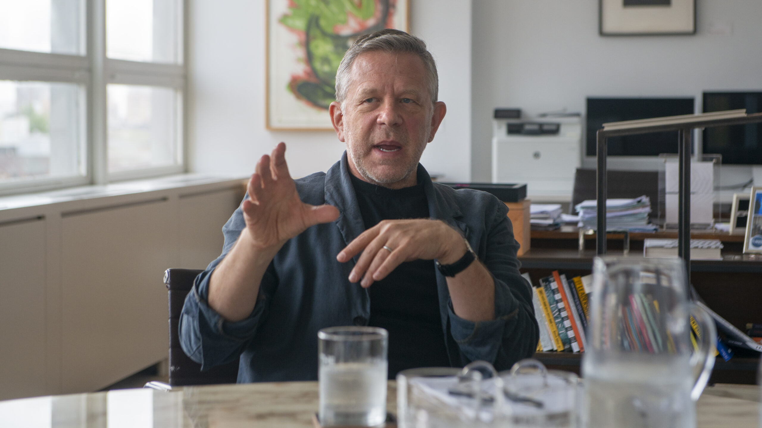 A candid portrait of New School President Joel Towers as he sits at his conference table.