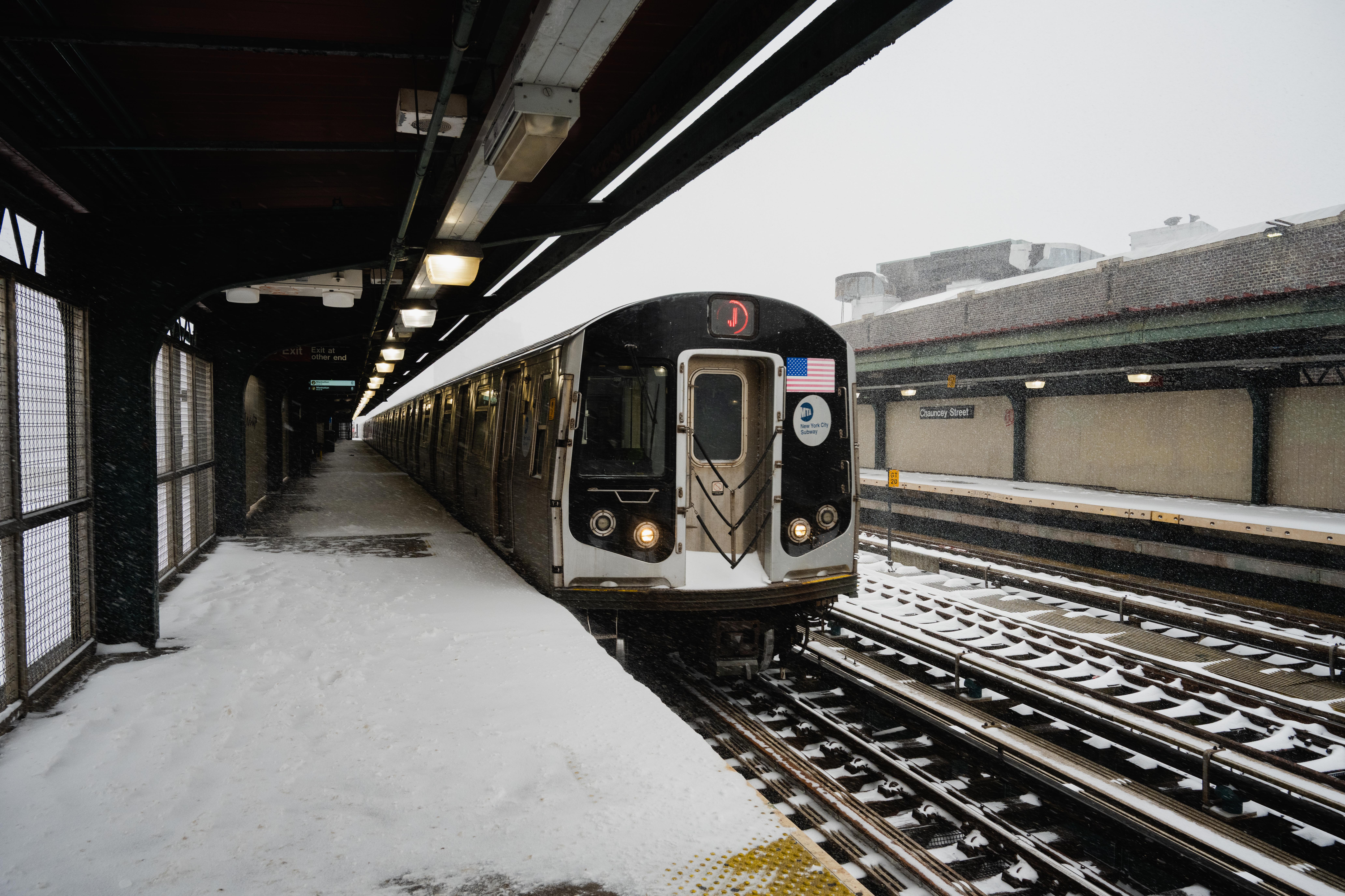 Train at a semi-outdoor station during a snow storm.
