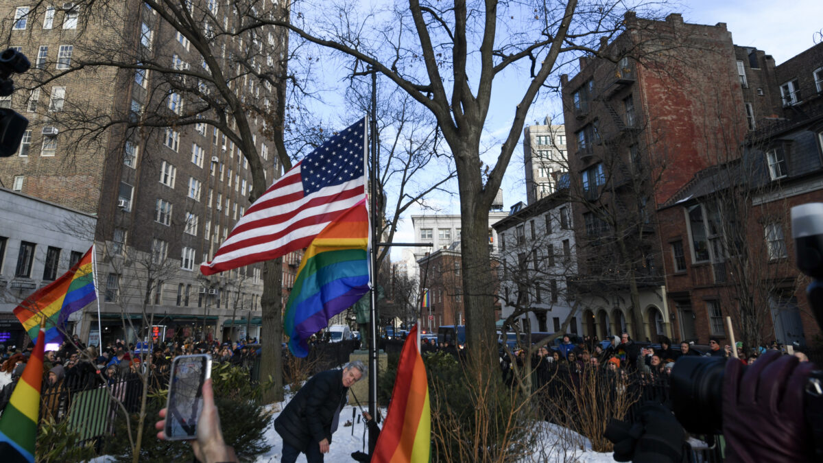 SLUG_MR_260216_0000_Sigal-flag-raised A man stood hunched over beneath a rainbow flag and a U.S. flag.
