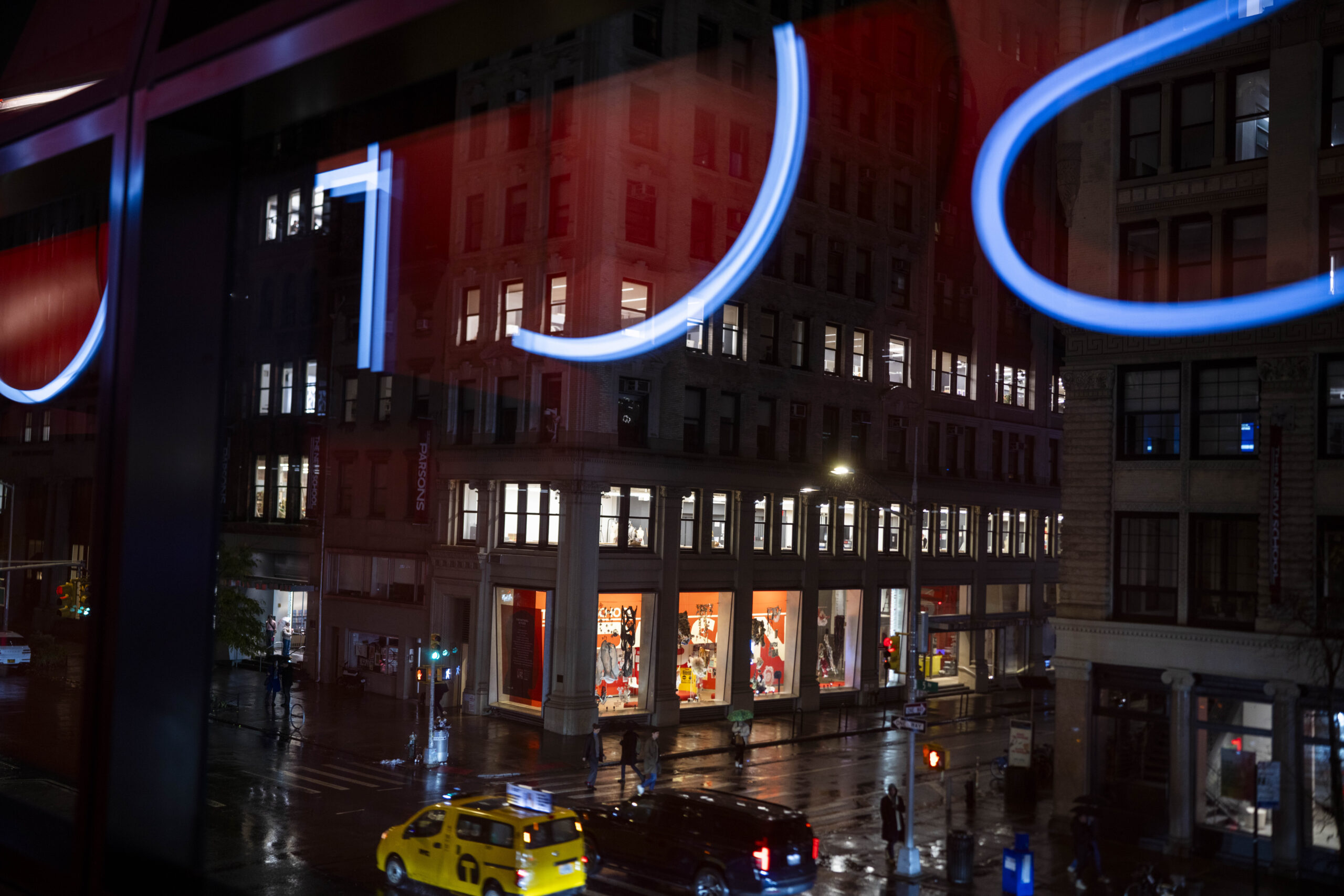 Street view out of a University Center window at night. Lights reflect in the window.
