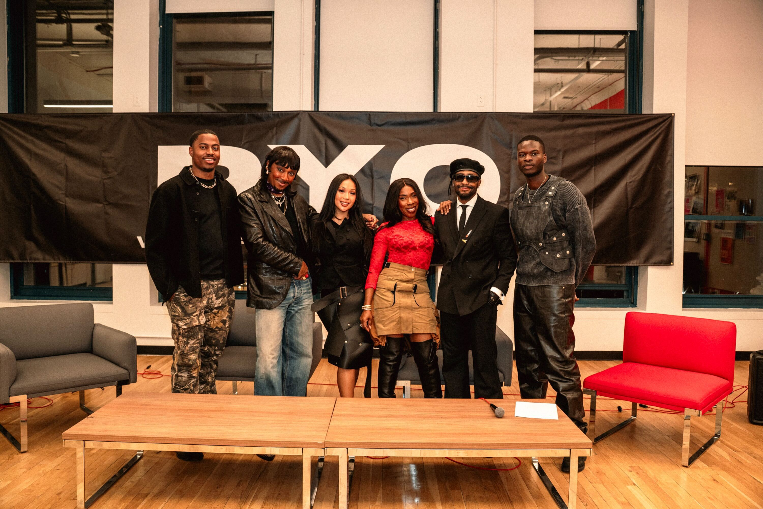 Photo of the co-founders and panelists in front of a large black-and-white banner that reads PYO.