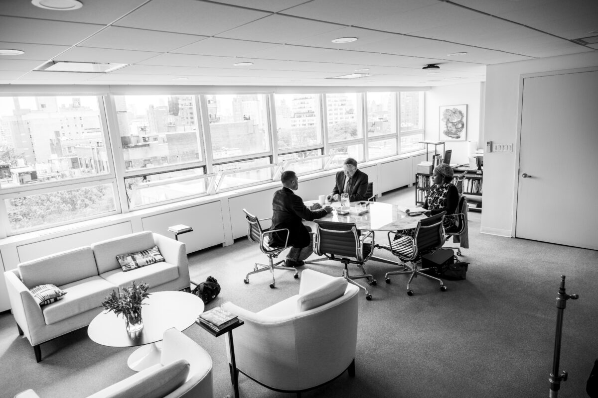 Jayden DeGraftenreed, Joel Towers, Merrie Snead, sit at a glass table in Towers’ large window-lined office on the eighth floor of Alvin Johnson/J.M. Kaplan Hall."Eugene Lang.